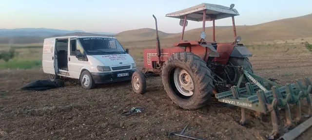 Tarlada kırmızı traktörün lastik tamiri