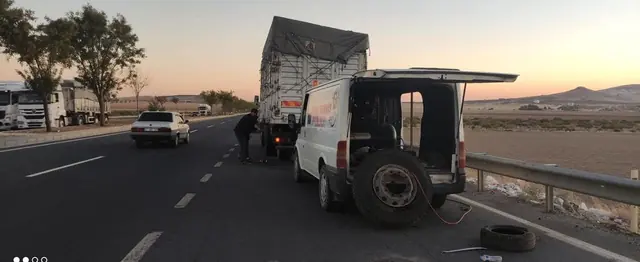 Gün batımında karayolunda kamyon lastiği için yol yardım